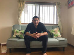 Rob Kajiwara sitting on couch
